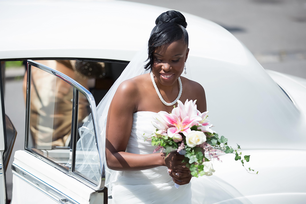 Bride with flowers getting out of the car
