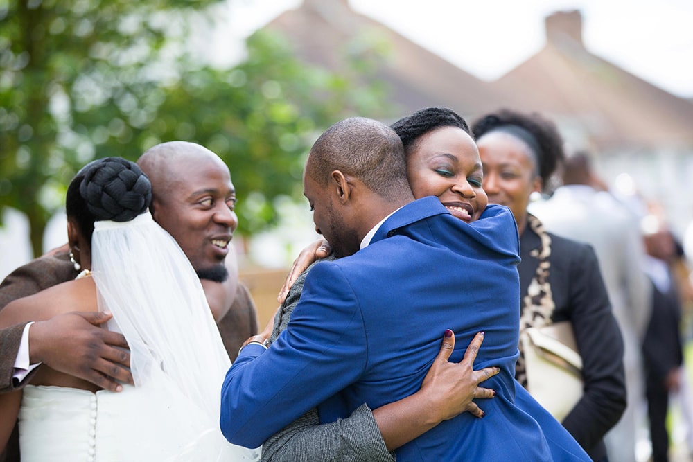 Bride and groom hugging their parents