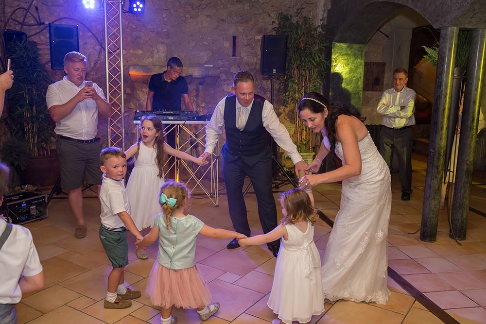 Bride and groom dancing with children