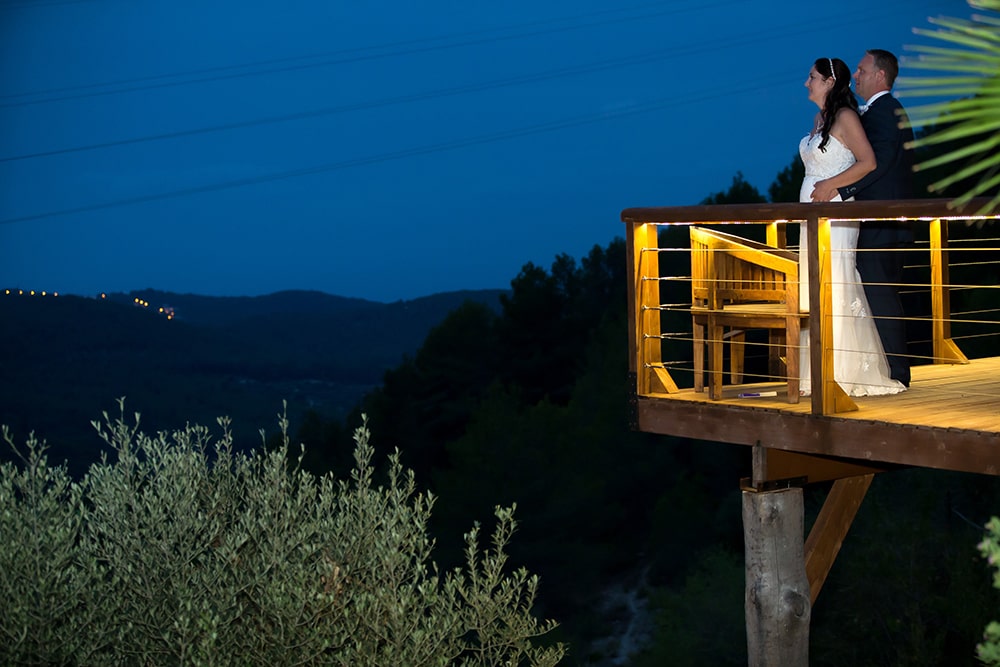 Bride and groom standing on the balcony at night