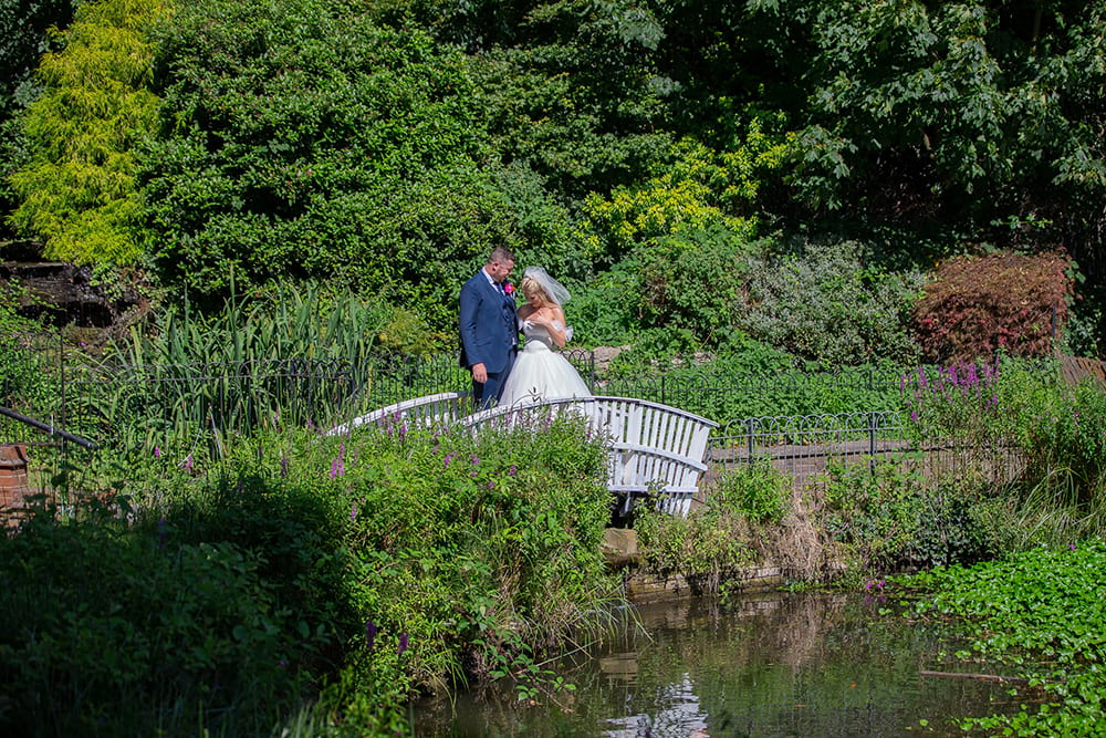 Bride and groom standing on a small bridge