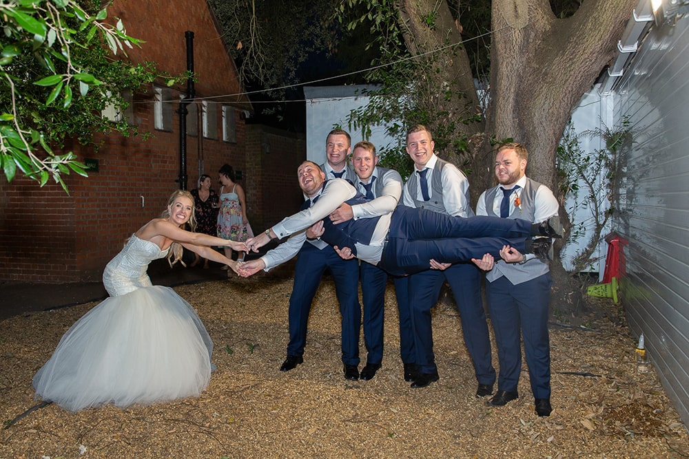Groom being held by his four friends