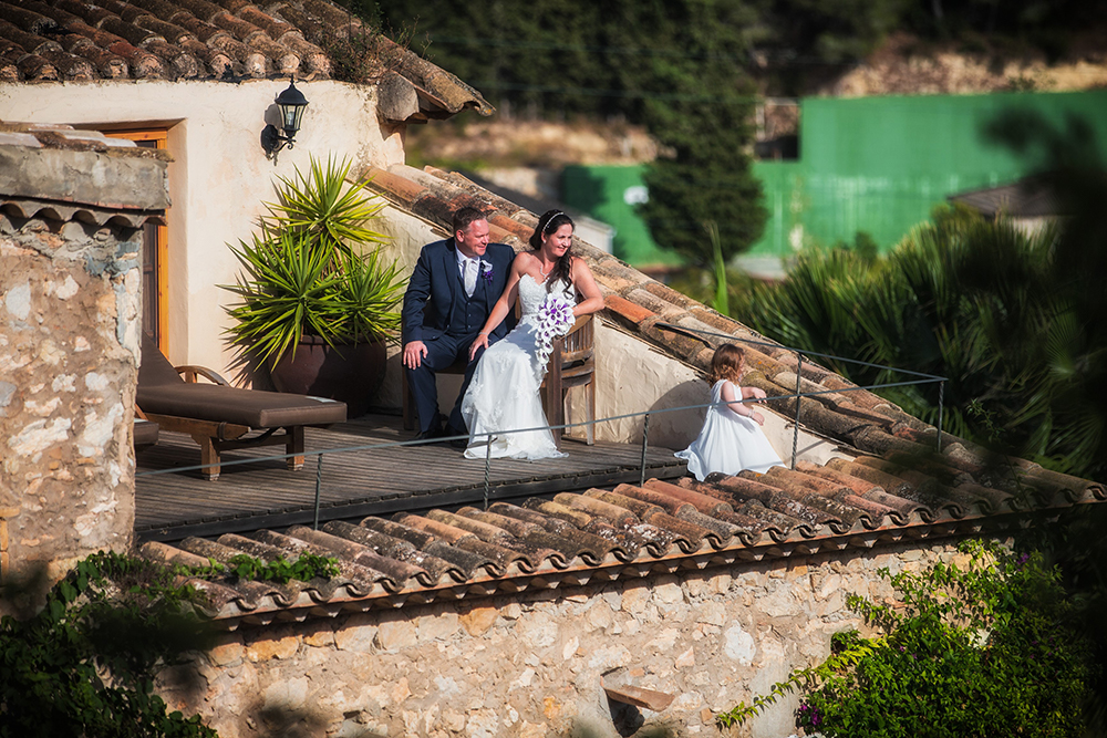 Bride and groom sitting on the roof of the house